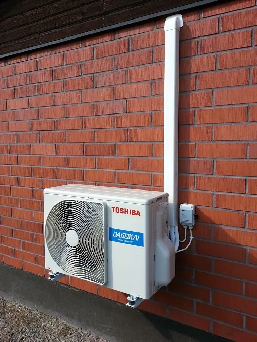 Toshiba-ilmalämpöpumpun ulkoyksikkö tiiliseinällä