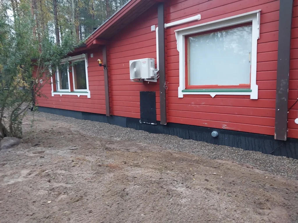 Sokkelieriste asennettuna punaisen puutalon perustuksiin