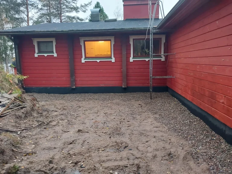 Sokkelieriste asennettuna punaisen talon perustuksiin, piha kesken